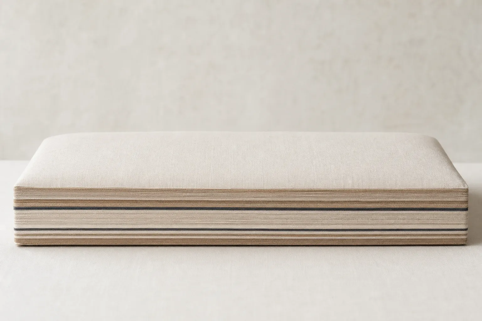 Front view of the STRATA pillow on a warm off-white ground, catalogue style.